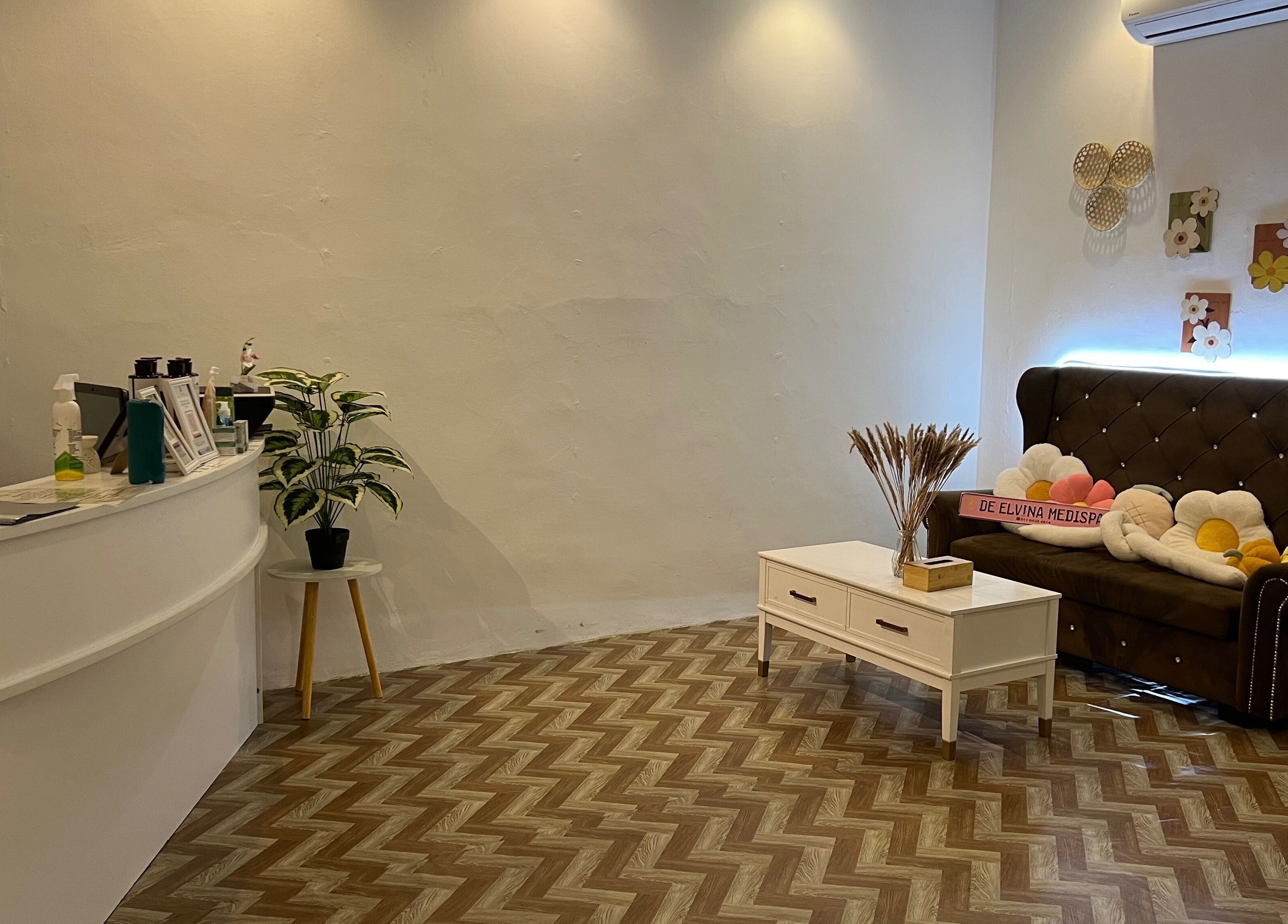 Cozy seating area at De Elvina Medispa, Muar, Johor, MY with brown sofa and decorative pillows.