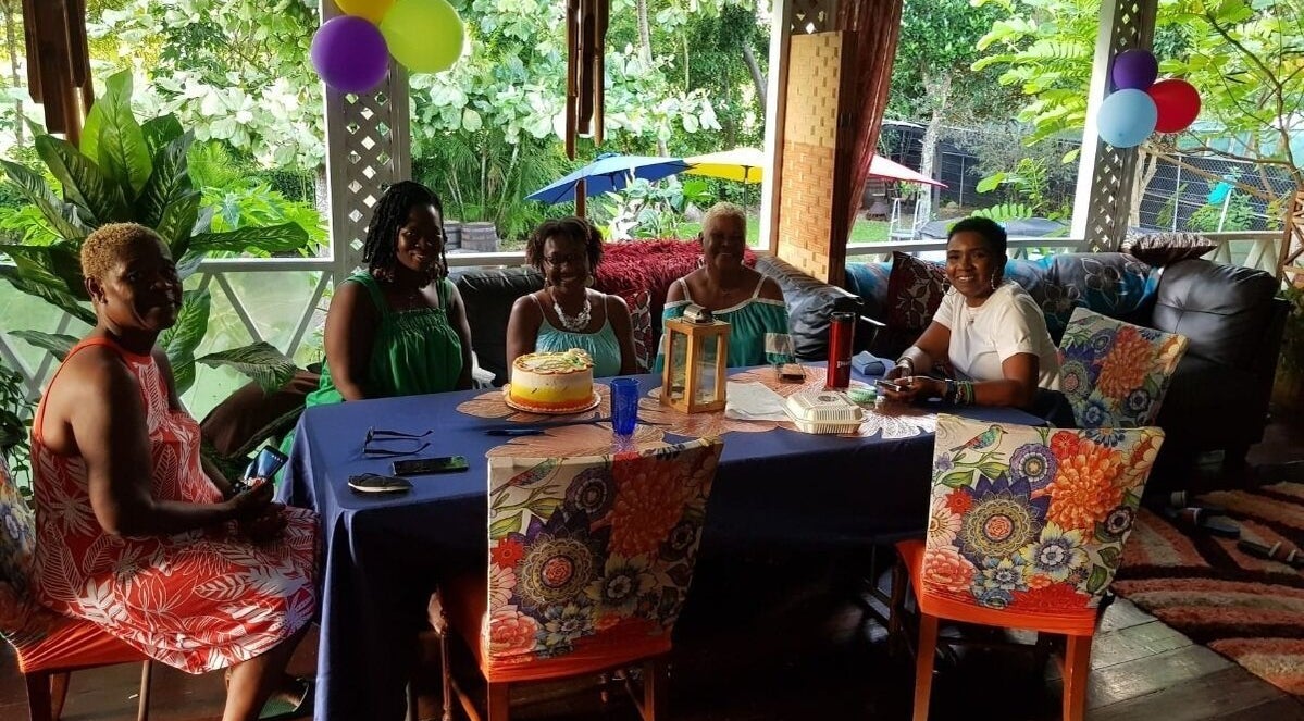 Group enjoying a celebration at Spa Holistic Health and Wellness, St. John, BB, with colorful decor.