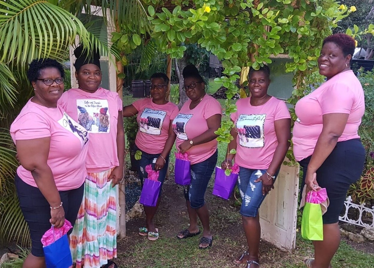 Guests smiling in pink shirts at Spa Holistic Health and Wellness, St. John, BB garden.