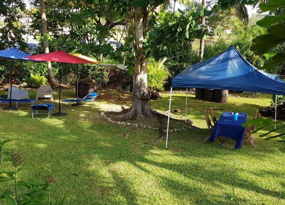 Relaxing outdoor space at Spa Holistic Health and Wellness, St. John, BB, featuring loungers and shaded areas.
