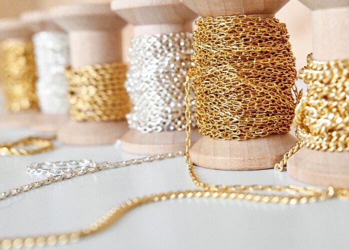 Elegant gold and silver chains on spools at Blush & Brow Beauty, Pointe-Claire, Québec, CA.