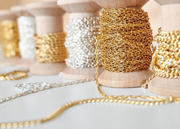 Elegant gold and silver chains on spools at Blush & Brow Beauty, Pointe-Claire, Québec, CA.