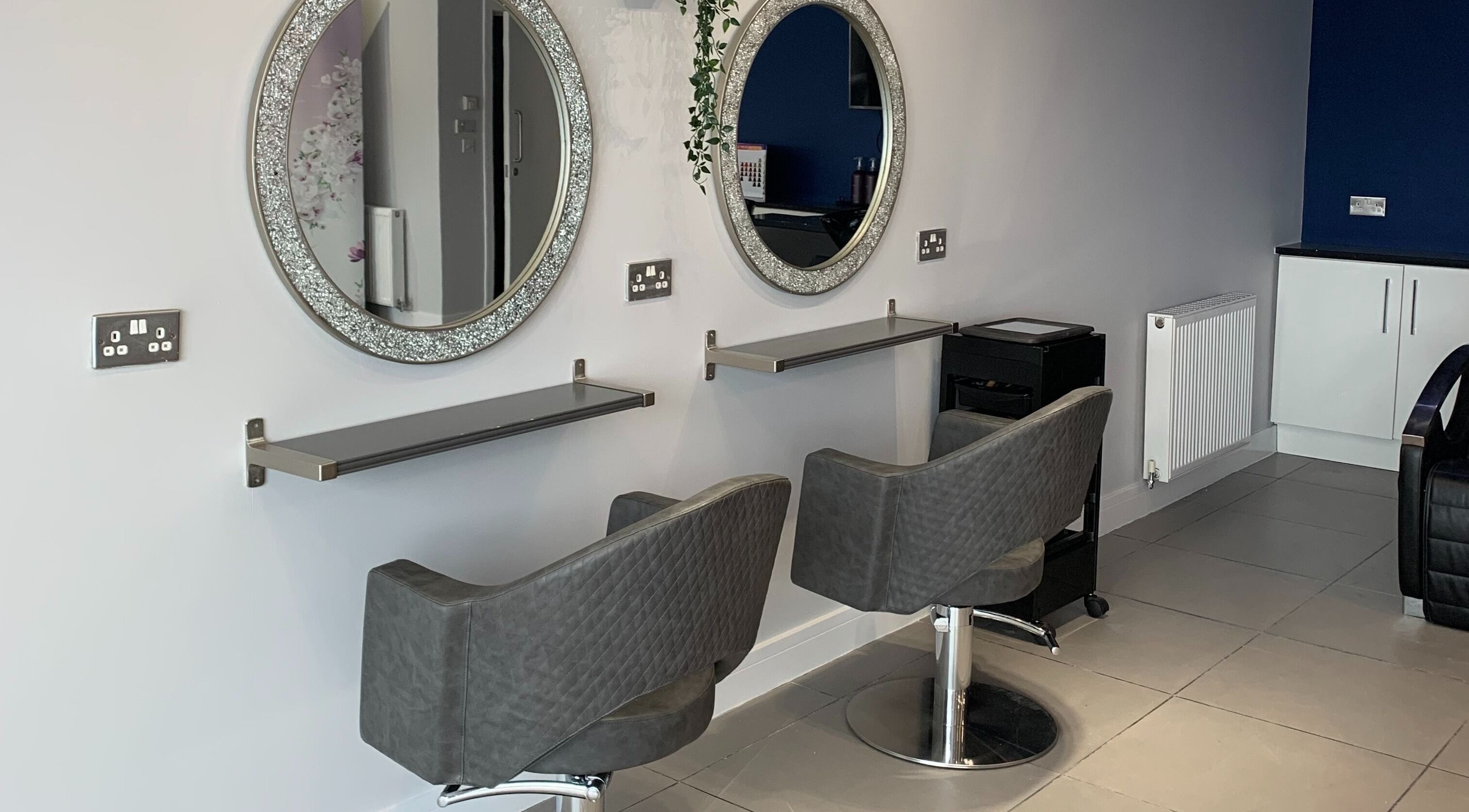 Elegant salon setup at KV Hair, Rotherham, England, GB with stylish chairs and mirrors.