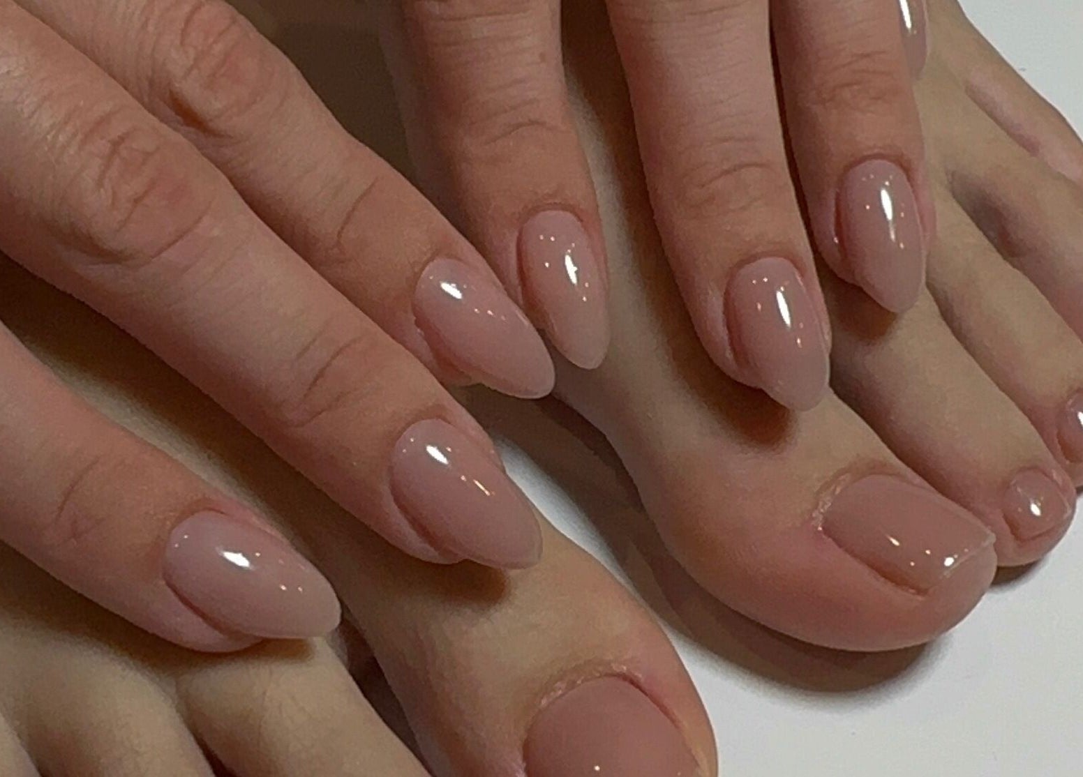 Manicured hands and pedicured feet with nude polish at Nails Lab, Calgary, Alberta, CA.