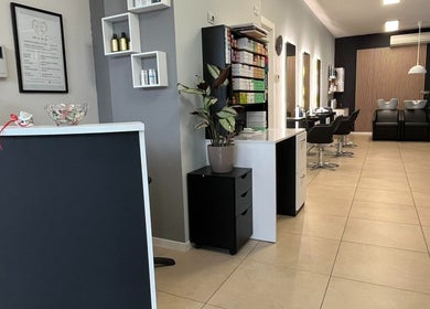 Interno moderno di EX Prestige Parrucchieri a Legnago, Veneto, IT, con posti a sedere stilizzati e ambiente pulito.