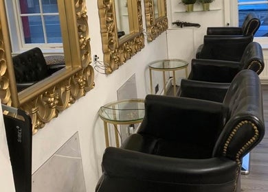 Luxurious seating at AE HAIR in Grimsby, England, GB with ornate mirrors reflecting stylish decor.