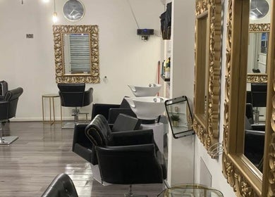 Chic interior of AE HAIR in Grimsby, England, GB, featuring ornate mirrors and sleek styling chairs.
