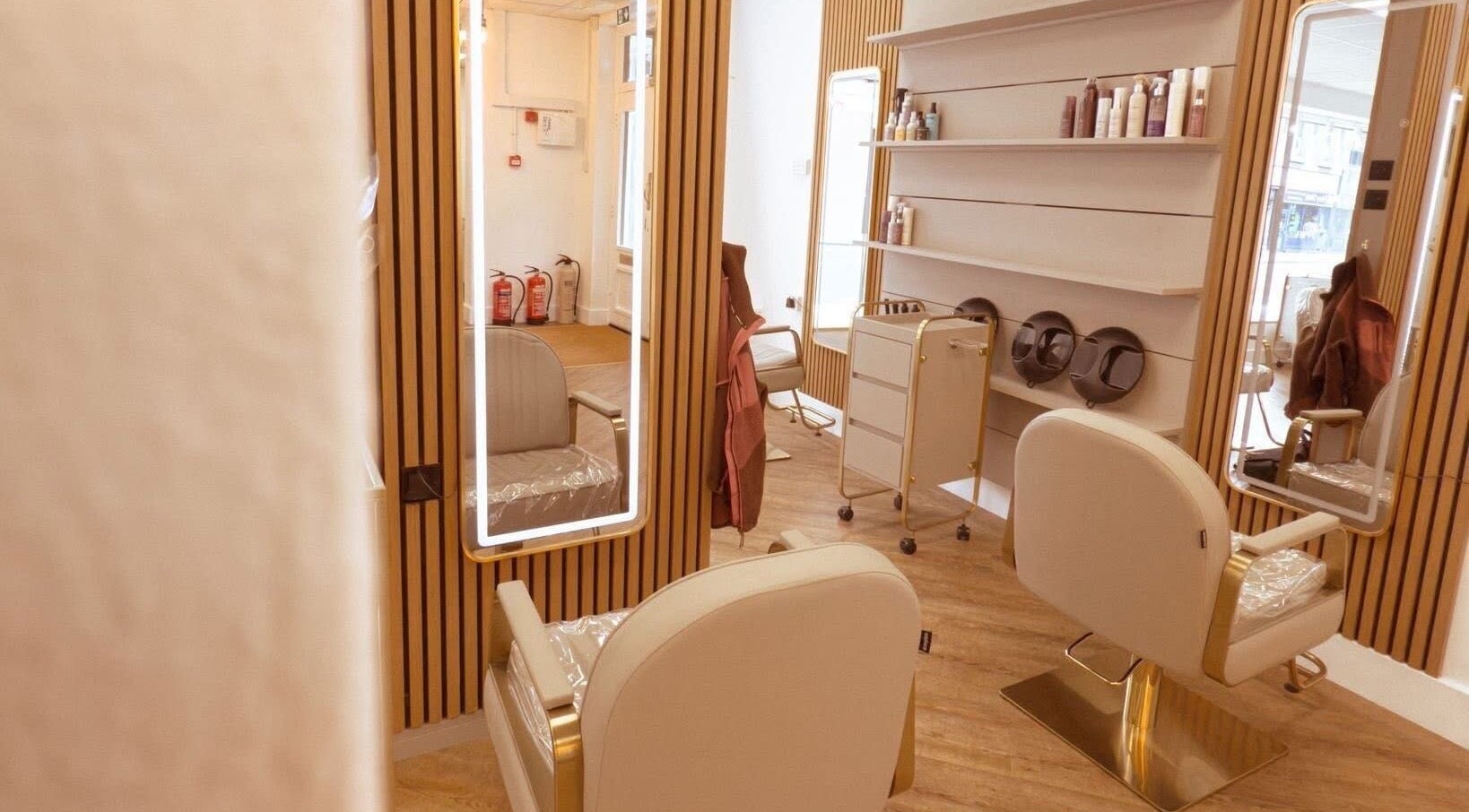 Modern salon interior at AE HAIR in Grimsby, England, GB featuring stylish chairs and mirrors.