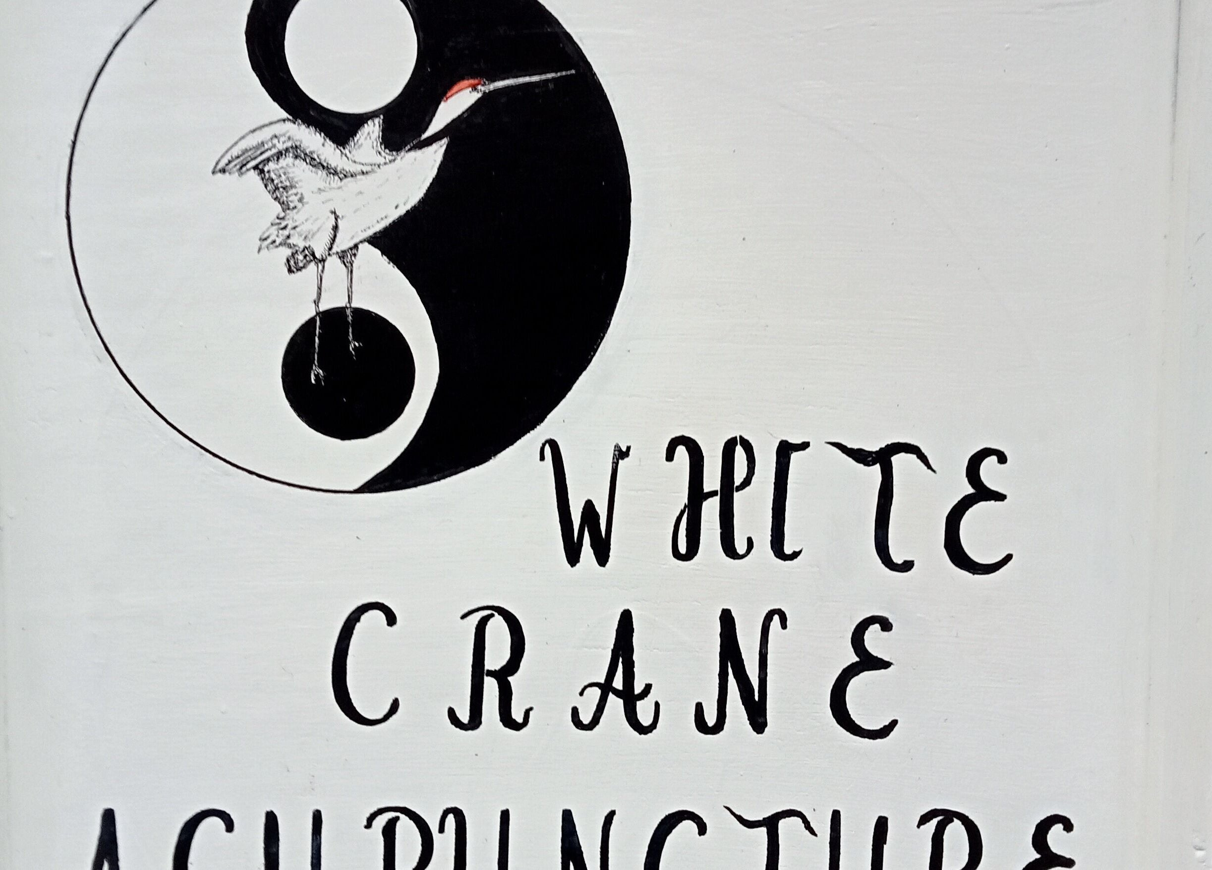 Sign with crane and yin-yang at White Crane Acupuncture, Mansfield, GB.