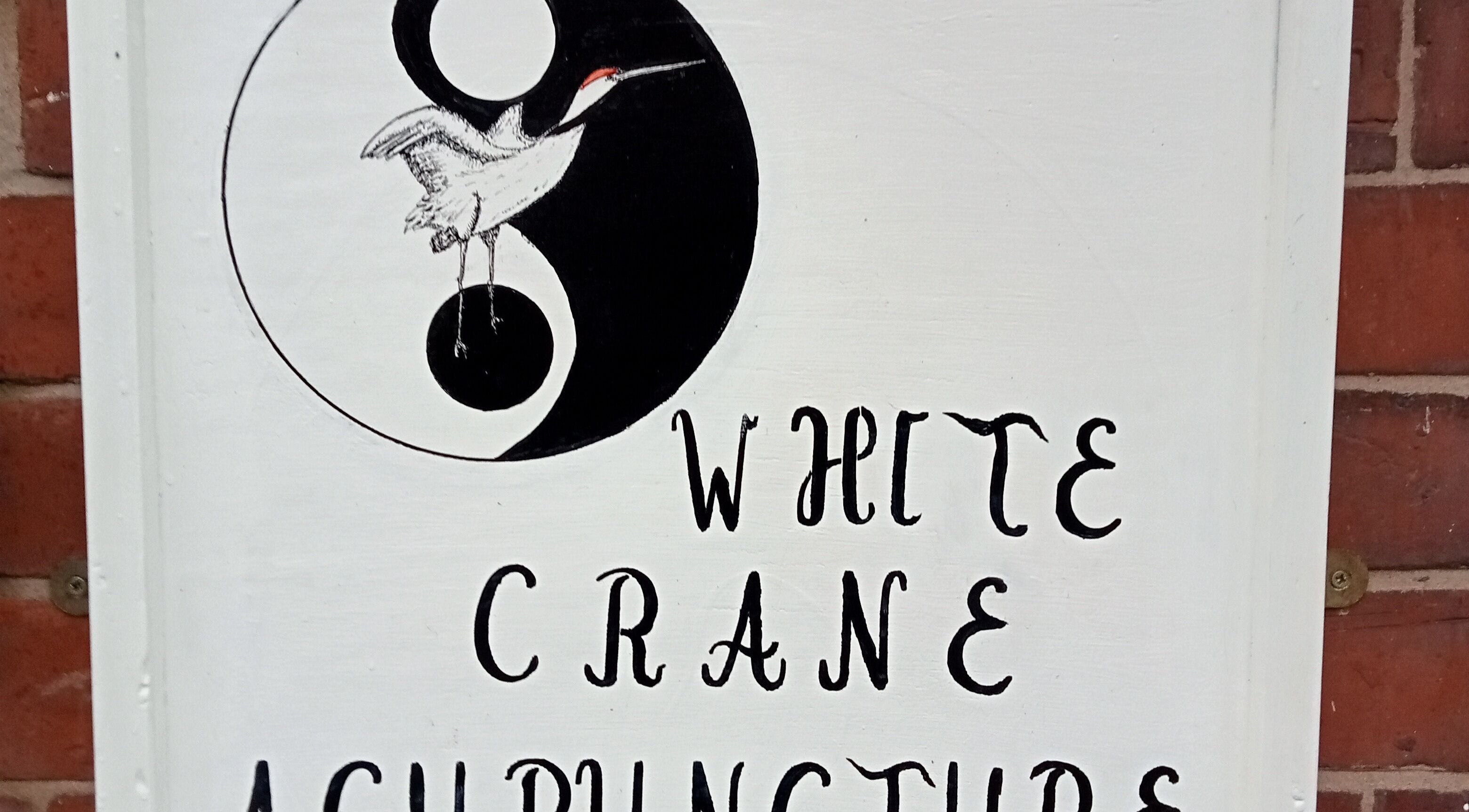 Sign with crane and yin-yang at White Crane Acupuncture, Mansfield, GB.