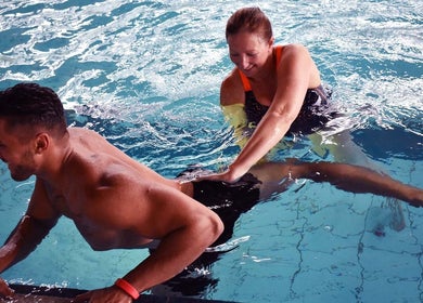 Therapist aiding man in exercise at The Pool @ Aspire, Stanmore, England, GB.
