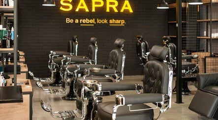 Interior moderno de SAPRA Barbershop en Miraflores, Provincia De Lima, PE, con sillas elegantes y ambiente acogedor.
