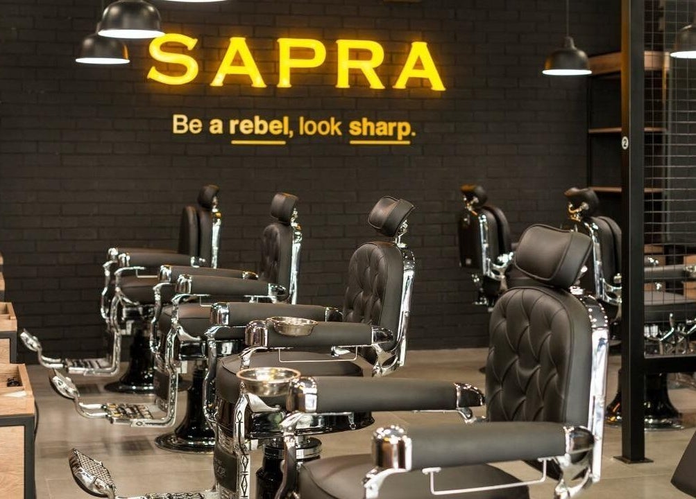 Interior moderno de Sapra Barbershop en Miraflores, Provincia De Lima, PE, con sillas de barbería elegantes.