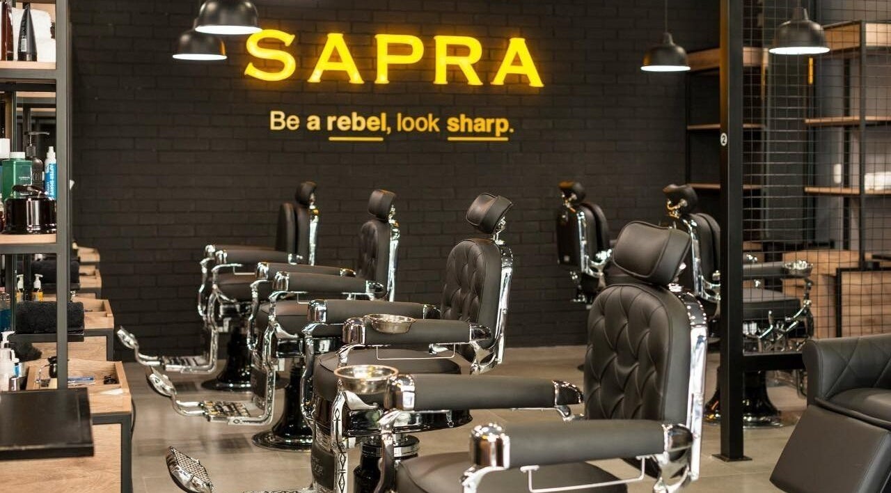 Interior moderno de Sapra Barbershop en Miraflores, Provincia De Lima, PE, con sillas de barbería elegantes.