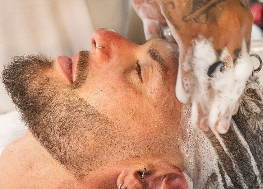 Hombre disfrutando de masaje capilar en Sapra Barbershop, Miraflores, Provincia De Lima, PE.