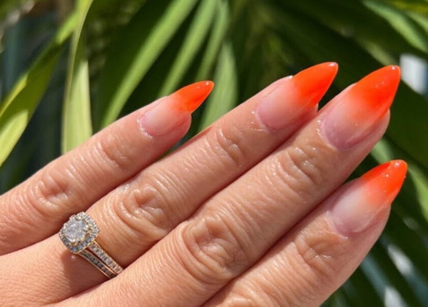 Vibrant ombre nails at Polished Nail and Brow Lounge, Dunedin, Florida, US, with a radiant ring in focus.