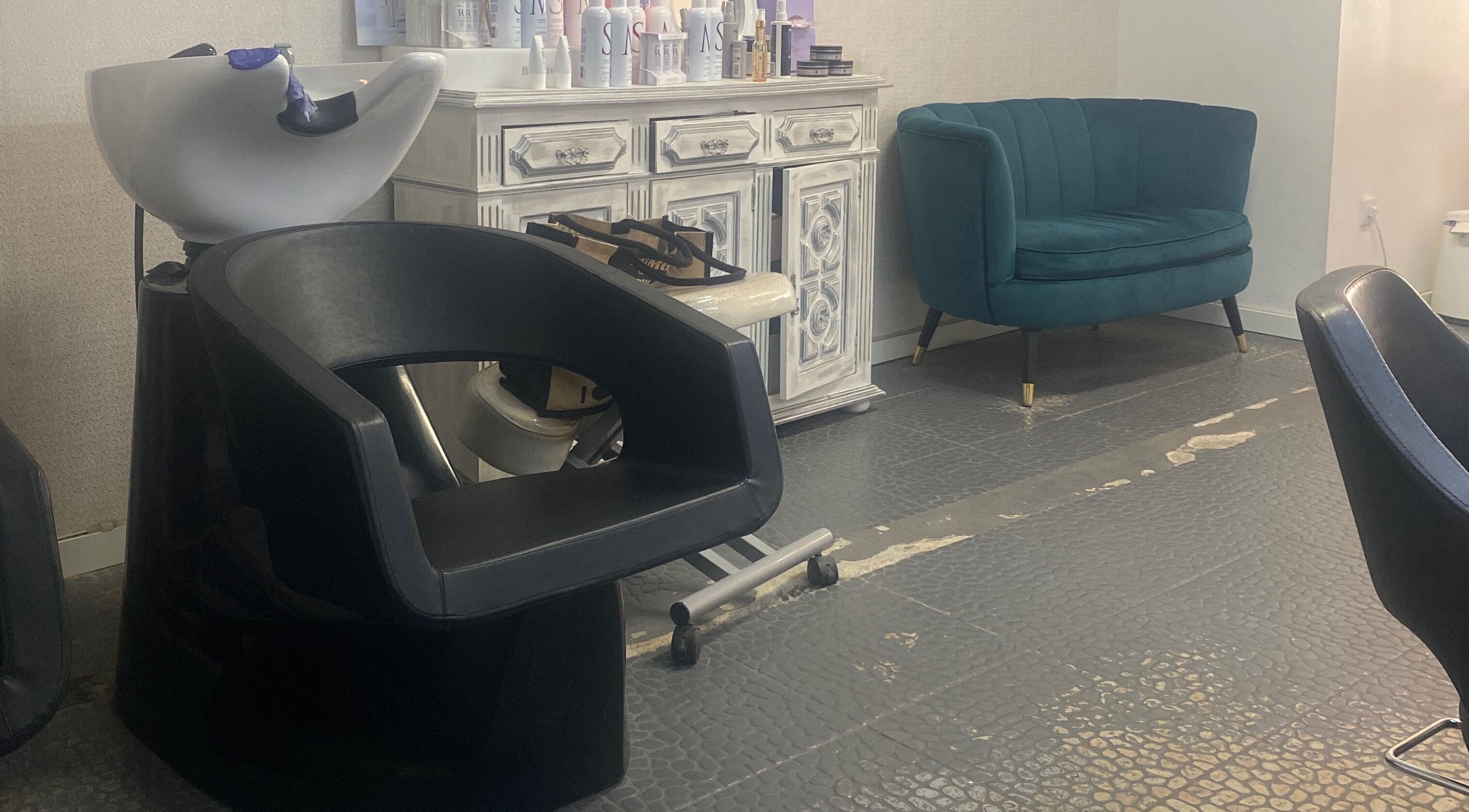 Área de espera elegante no Carla Lacerda Setúbal, Setúbal, PT, com sofá moderno e lavatório.