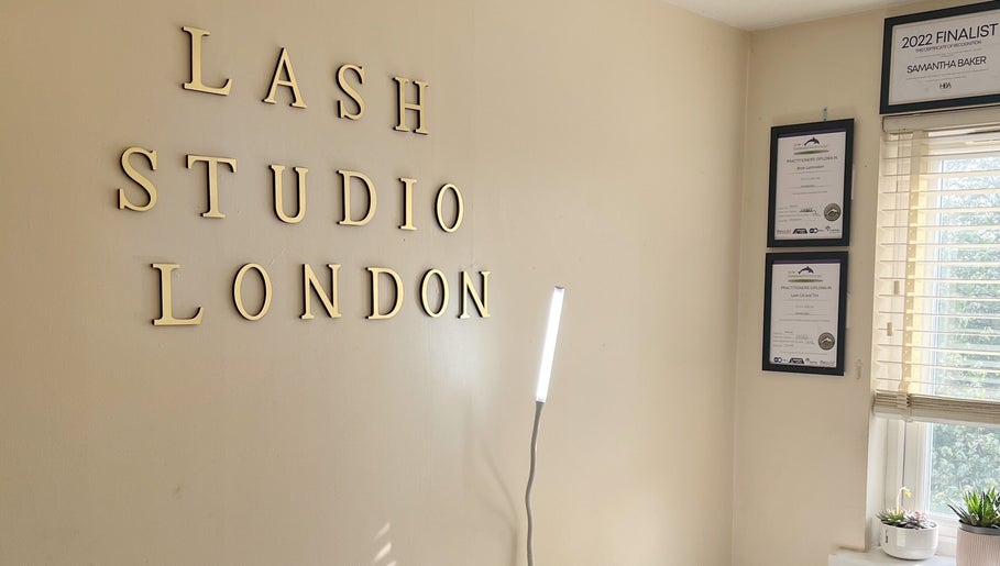Interior wall of Lash Studio London with certificates and tall lamp in London, England, GB.