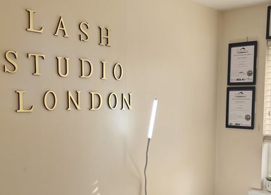 Interior wall of Lash Studio London with certificates and tall lamp in London, England, GB.
