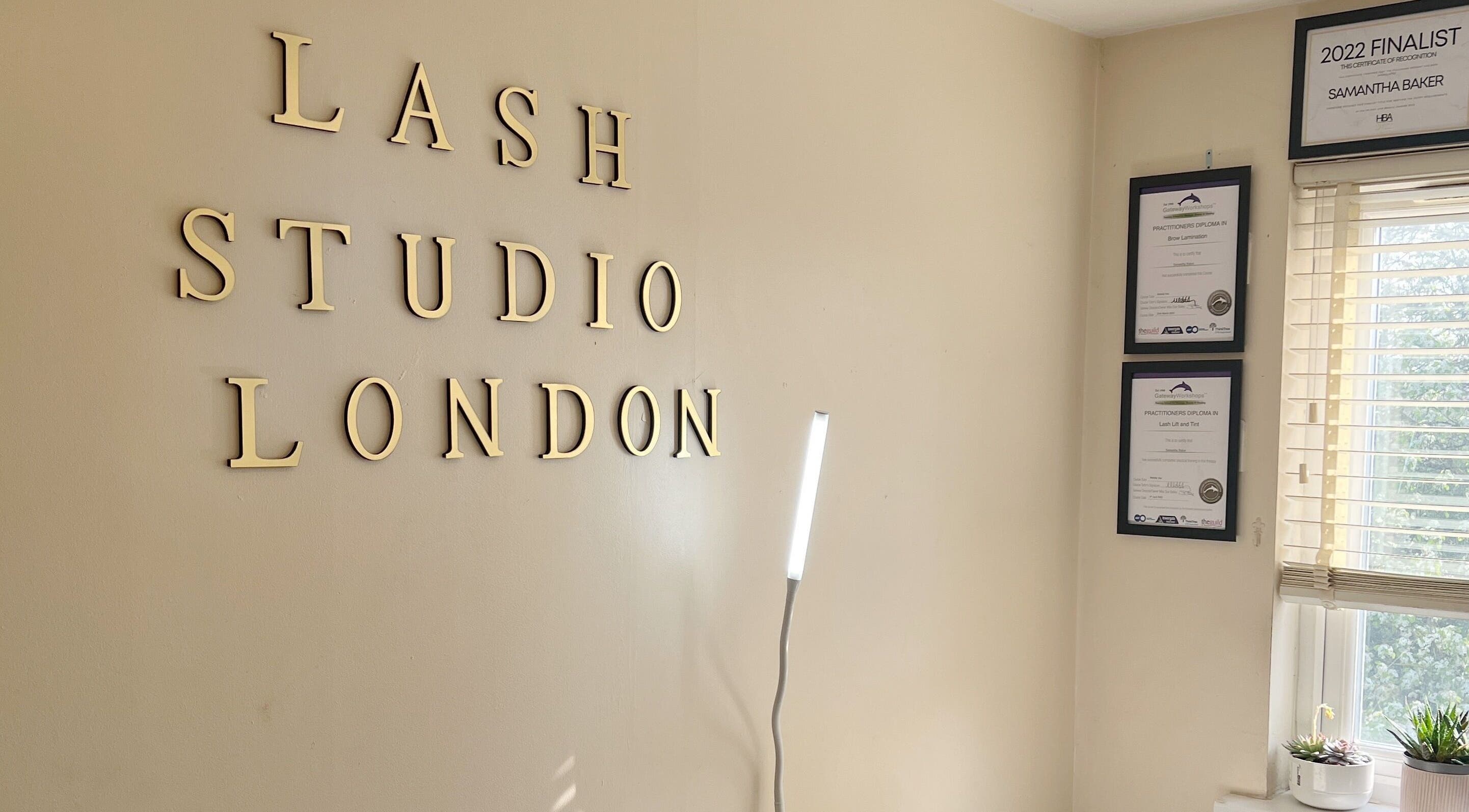 Interior wall of Lash Studio London with certificates and tall lamp in London, England, GB.