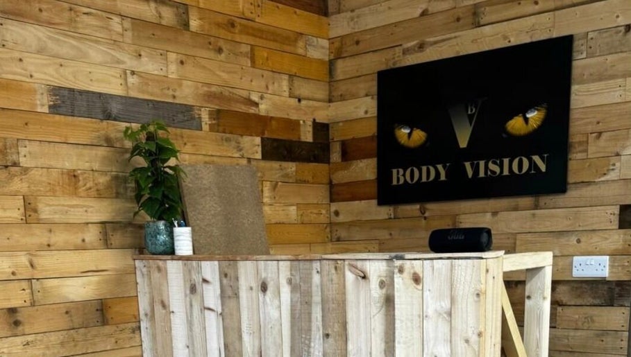 Bodyvision reception with wooden decor and a plant in Old Colwyn, Wales, GB.