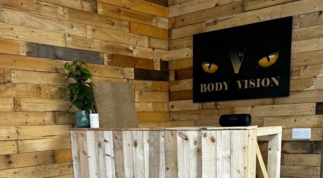Bodyvision reception with wooden decor and a plant in Old Colwyn, Wales, GB.
