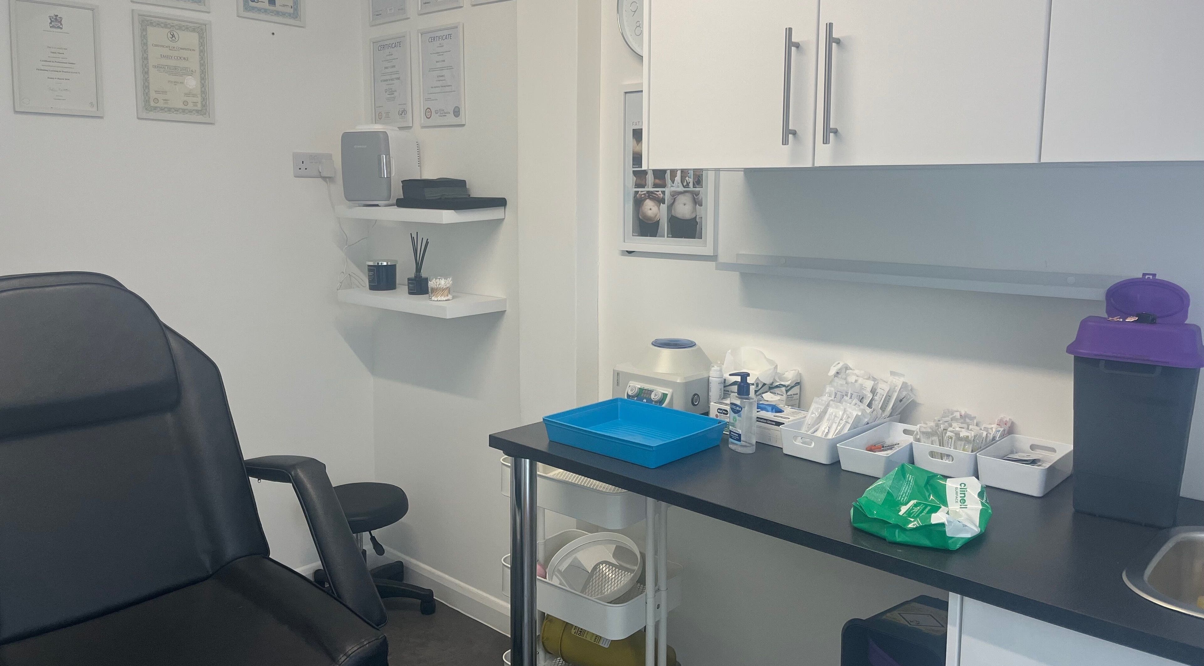 Calm treatment room at Mes Amis Aesthetics in Abbeydale, England, GB, showcasing equipment and certificates.