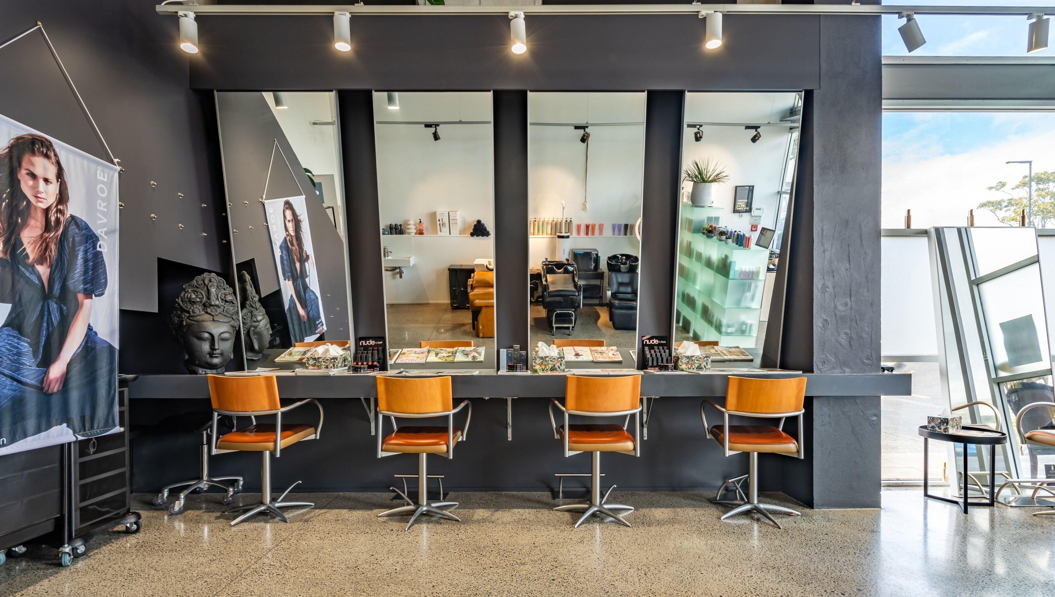 Elegant interior of The Colour Bar in Auckland, Auckland, NZ featuring modern salon chairs and wide mirrors.