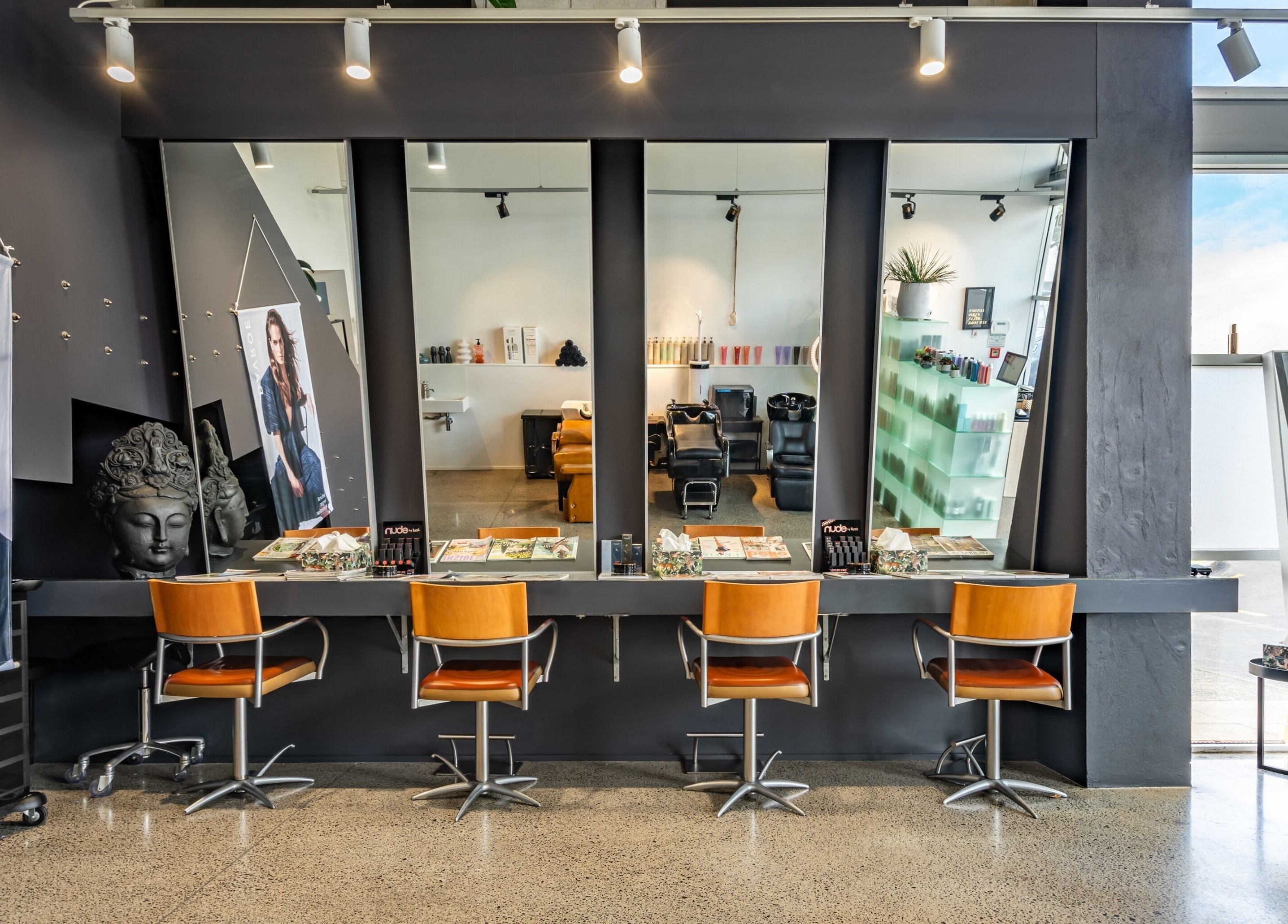 Elegant interior of The Colour Bar in Auckland, Auckland, NZ featuring modern salon chairs and wide mirrors.