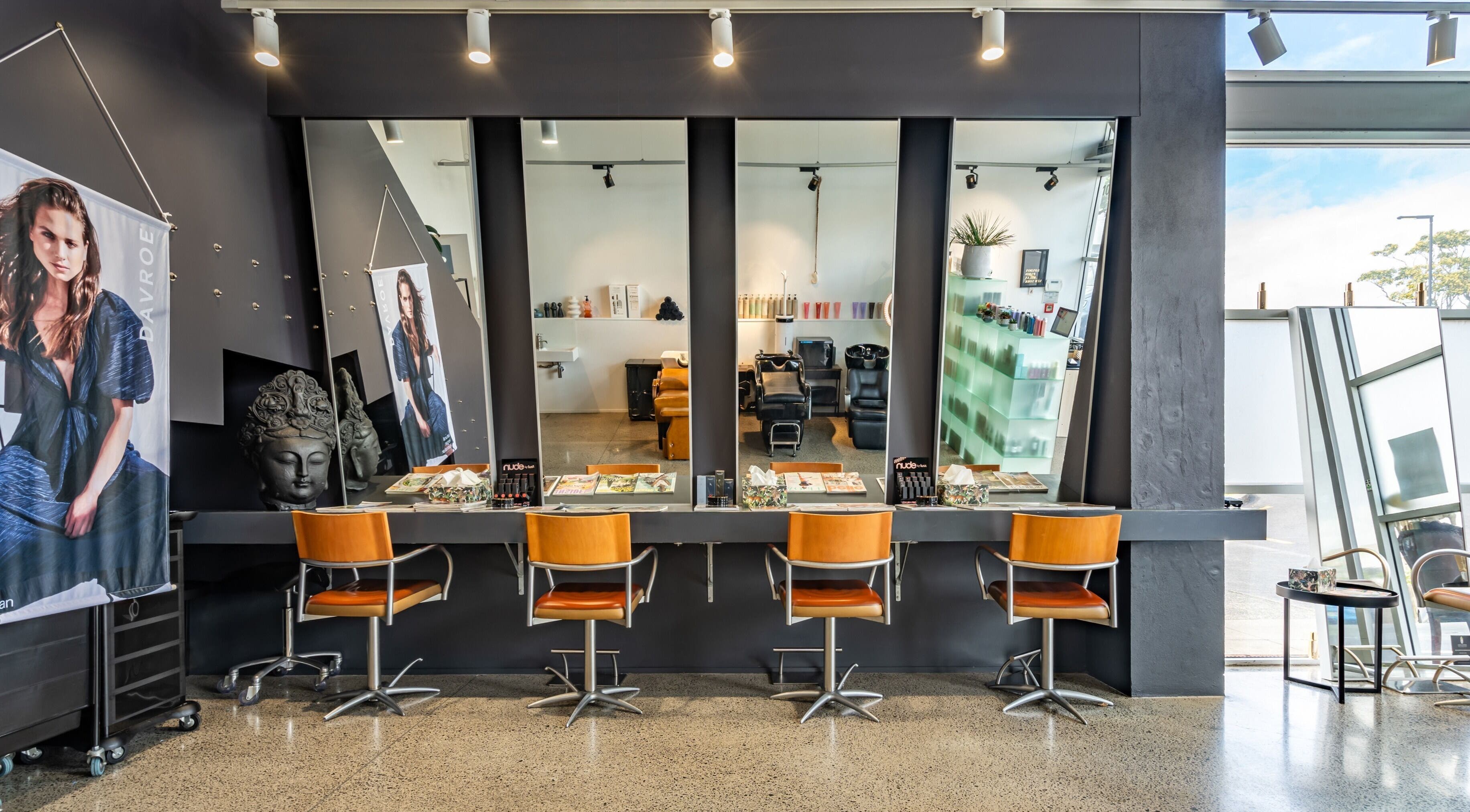 Elegant interior of The Colour Bar in Auckland, Auckland, NZ featuring modern salon chairs and wide mirrors.