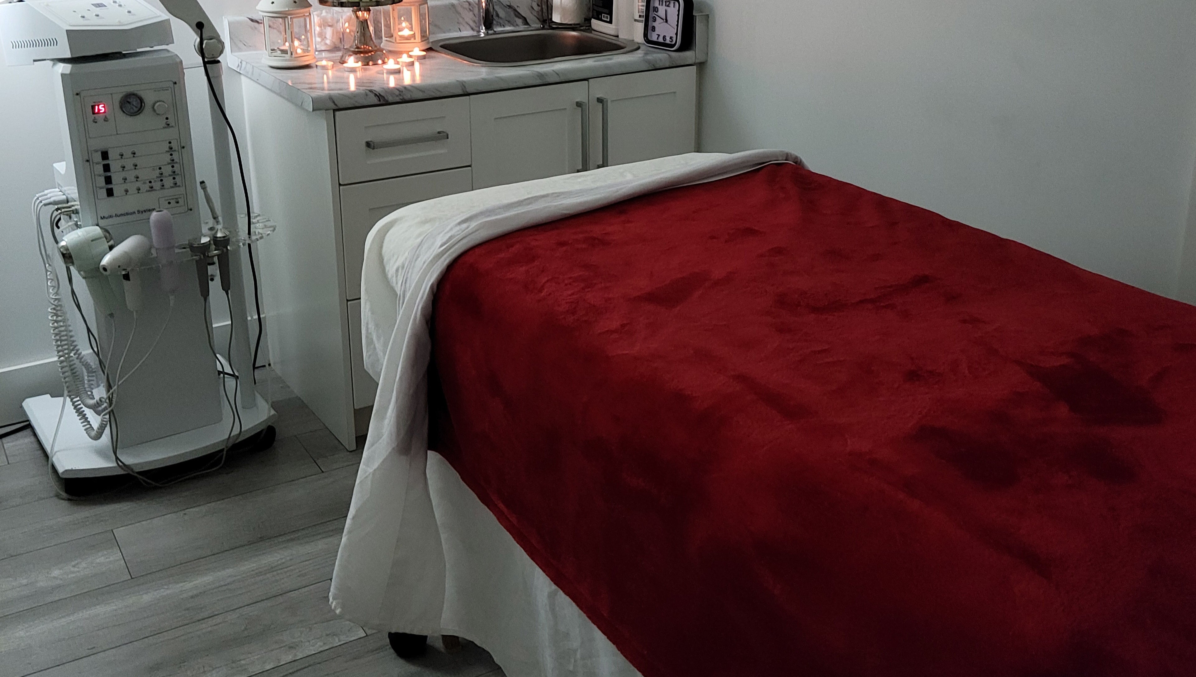Cozy treatment room at Healthy Skin and Wax in Langley Township, British Columbia, CA with red blanket and candles.