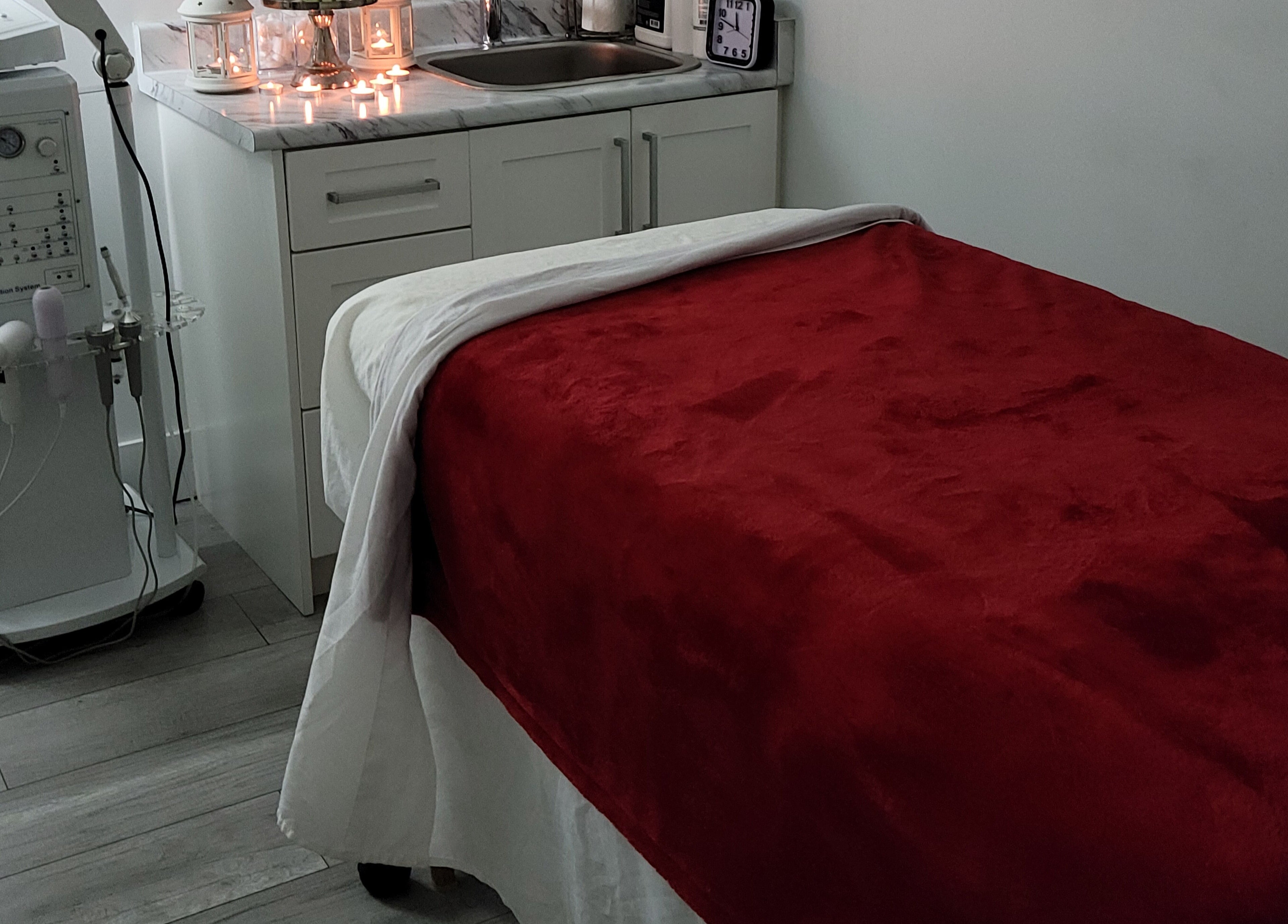 Cozy treatment room at Healthy Skin and Wax in Langley Township, British Columbia, CA with red blanket and candles.