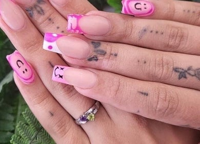Detailed nail art on hands at The Lash Lounge, Bridgwater, England, GB, with pink and smiley face designs.