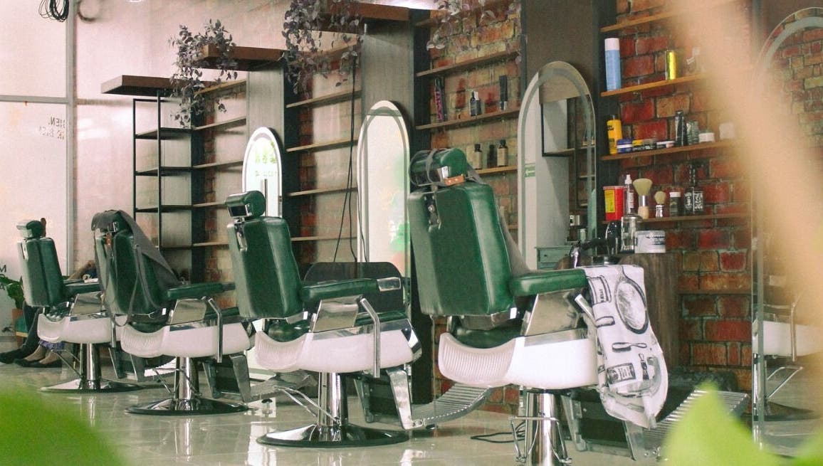 Interior moderno del Plaza Natura Garten Barberclub en Managua, NI, con sillones y espejos elegantes.