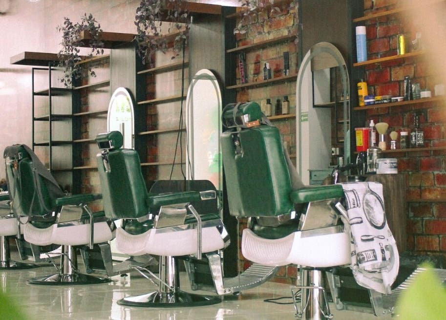 Interior moderno del Plaza Natura Garten Barberclub en Managua, NI, con sillones y espejos elegantes.