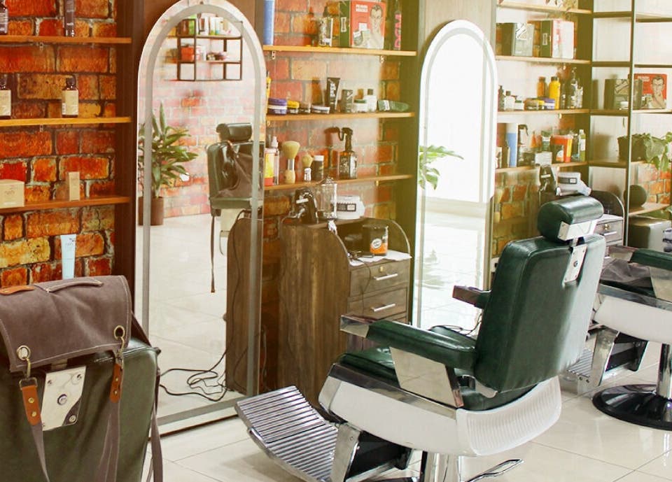 Interior moderno de Plaza Natura Garten Barberclub en Managua, Managua, NI con sillas elegantes y decoración rústica.