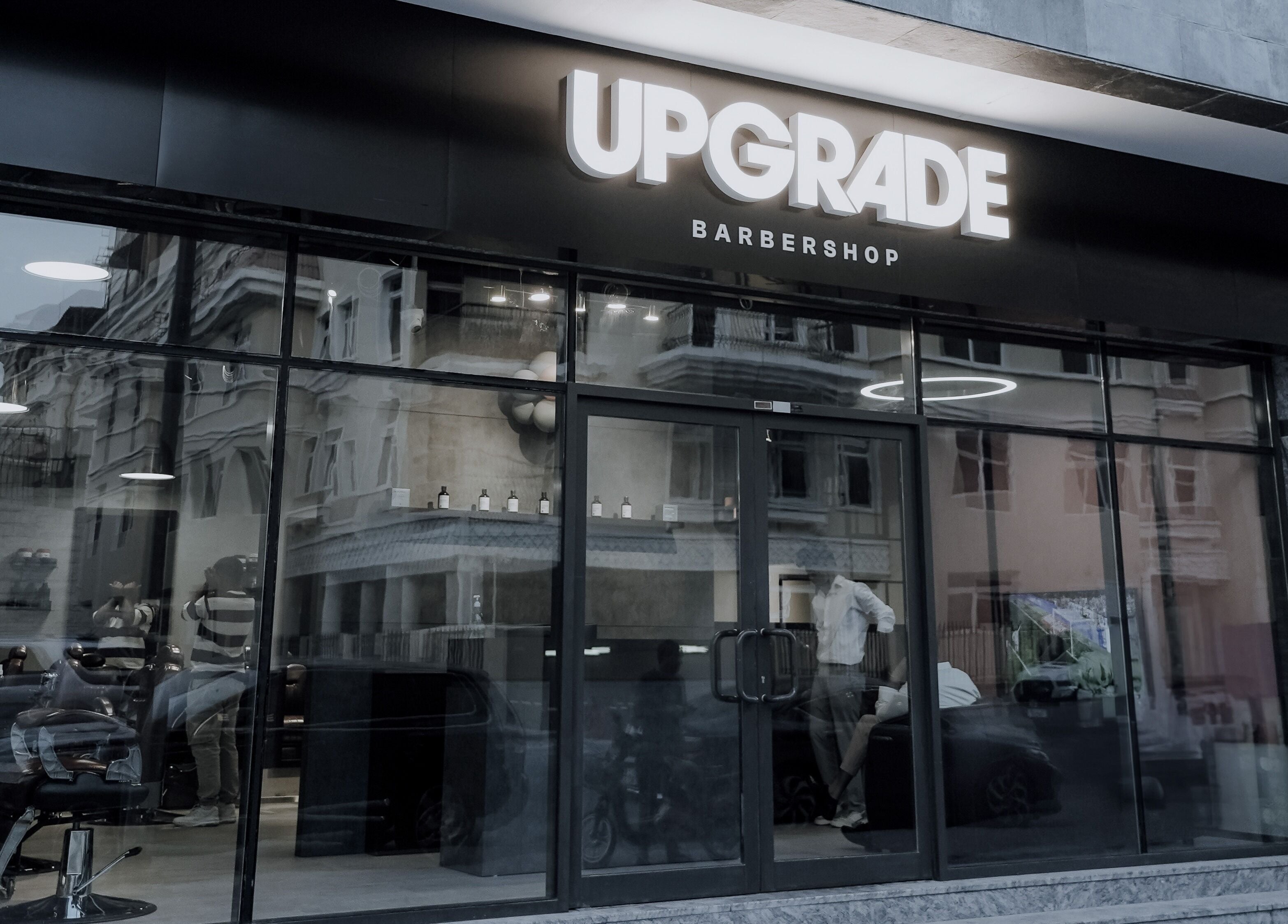 Exterior view of Upgrade Barbershop JVC in دبي, دبي, AE showing modern glass facade and signage.