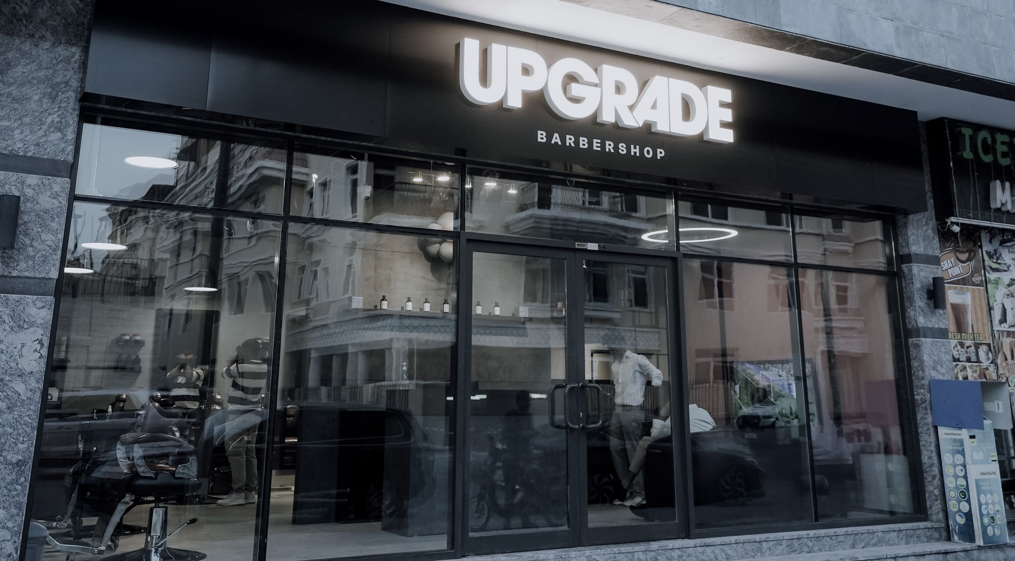 Exterior view of Upgrade Barbershop JVC in دبي, دبي, AE showing modern glass facade and signage.