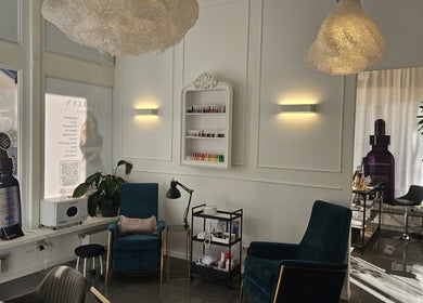 Sala d'attesa elegante di Evellyn Beauty a Lugano, Ticino, CH, con sedie blu e dettagli raffinati.