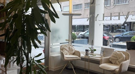 Elegante area d'attesa presso Evellyn Beauty, Lugano, Ticino, CH, con poltrone e decorazioni verdi.