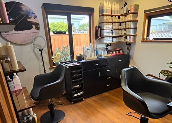 Modern salon setup at Unique Hair Design, Nelson, NZ with stylish chairs and shelves of beauty products.