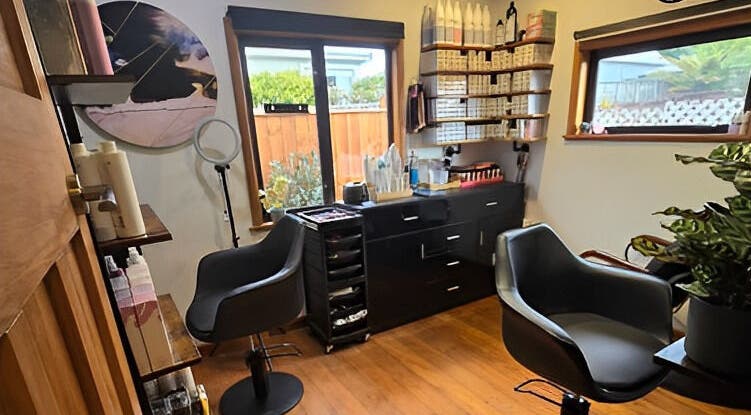 Modern salon setup at Unique Hair Design, Nelson, NZ with stylish chairs and shelves of beauty products.