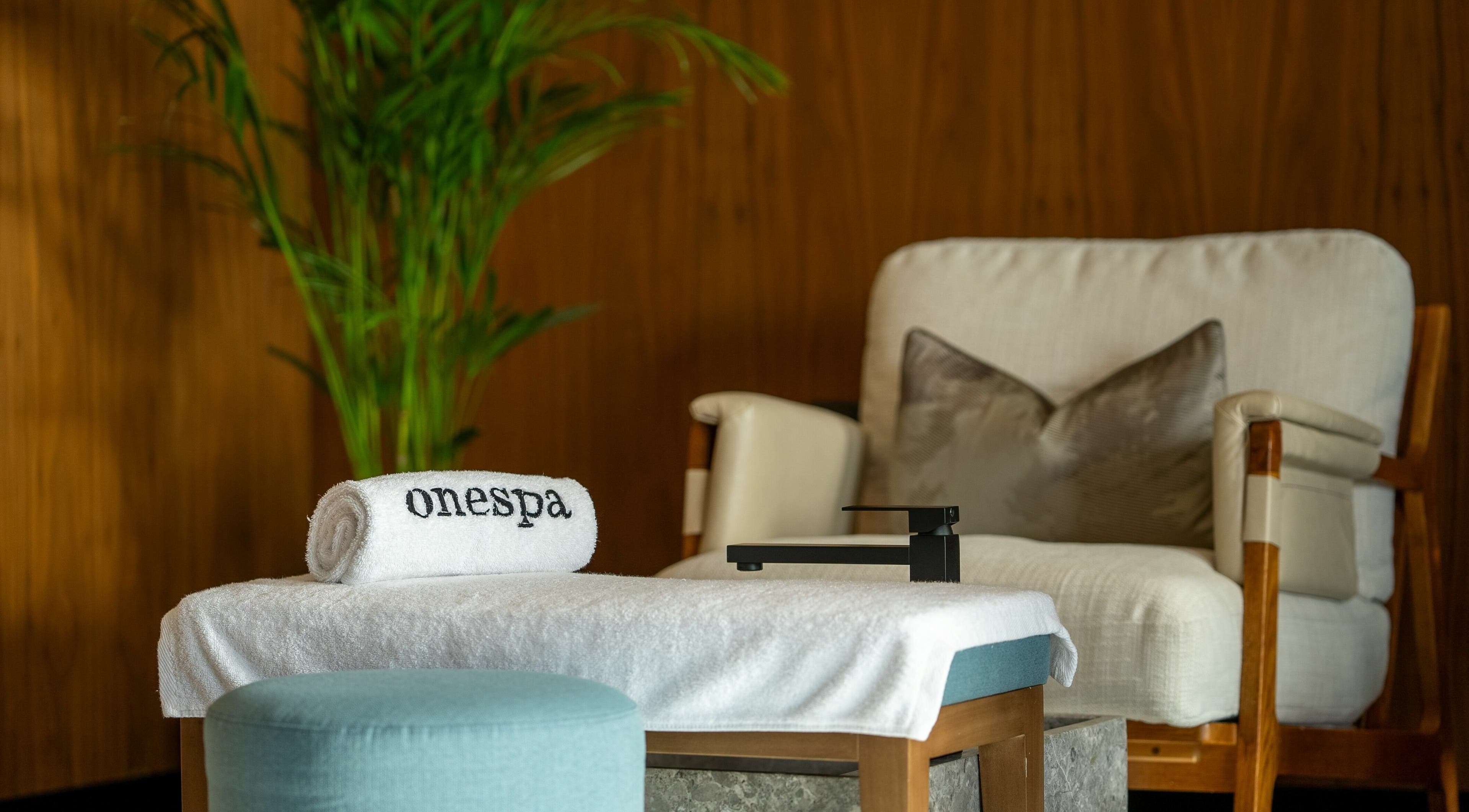 Relaxing lounge at One Spa, Riyadh, Riyadh Province, SA, with plush chair and towel.