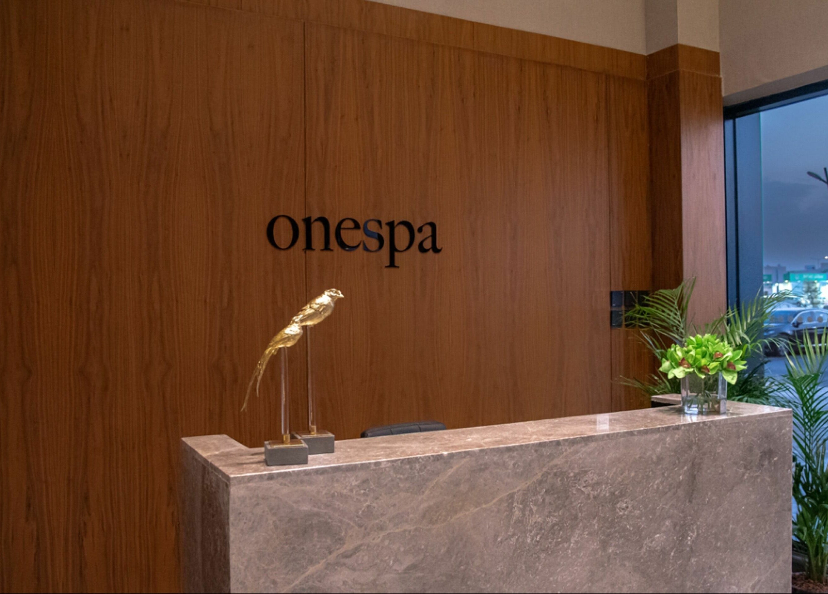 Sophisticated One Spa reception area in Riyadh, Riyadh Province, SA with modern decor and a golden sculpture.
