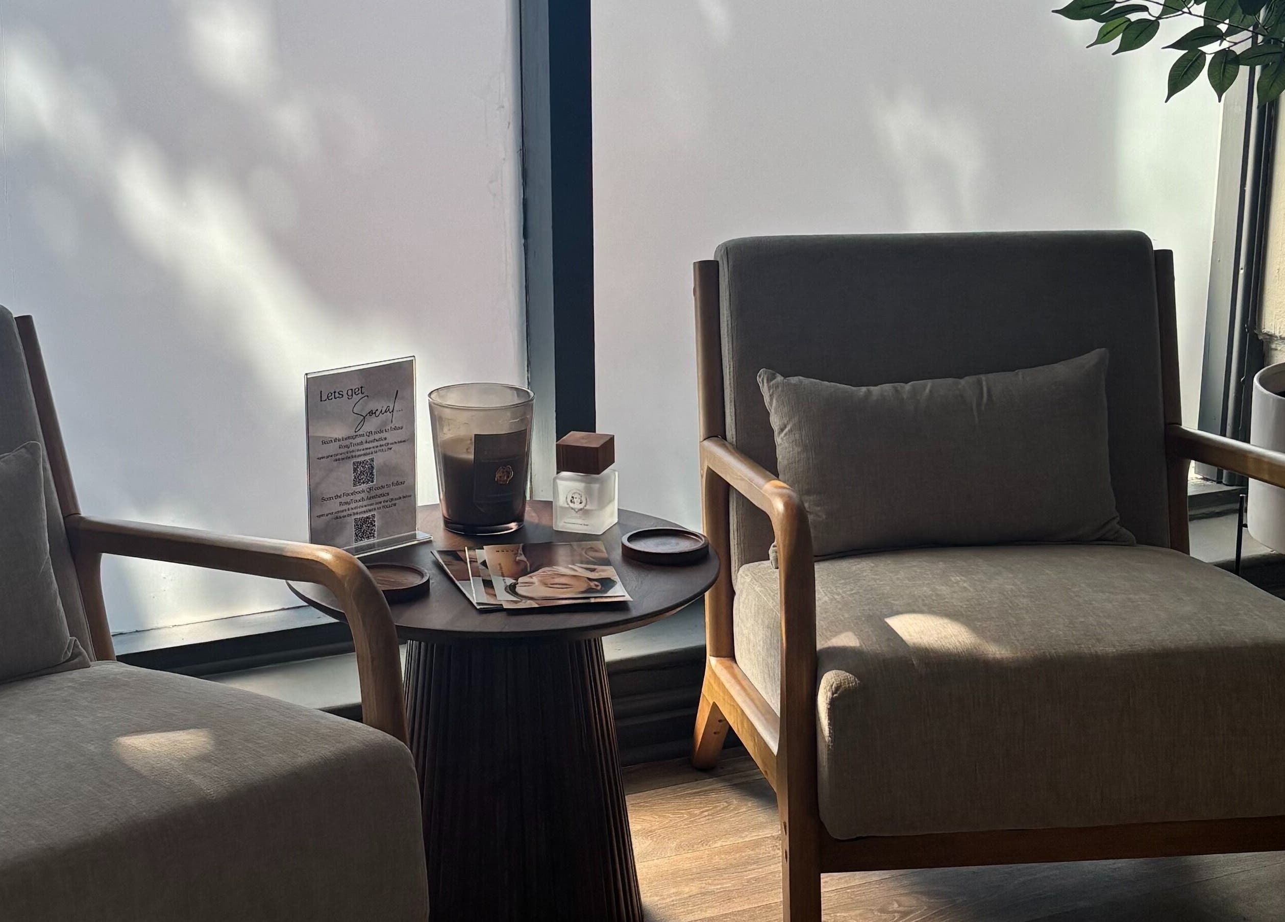 Cozy seating area at RosyTouch Aesthetics Ceres, Ceres, Western Cape, ZA, with wooden chairs and elegant decor.