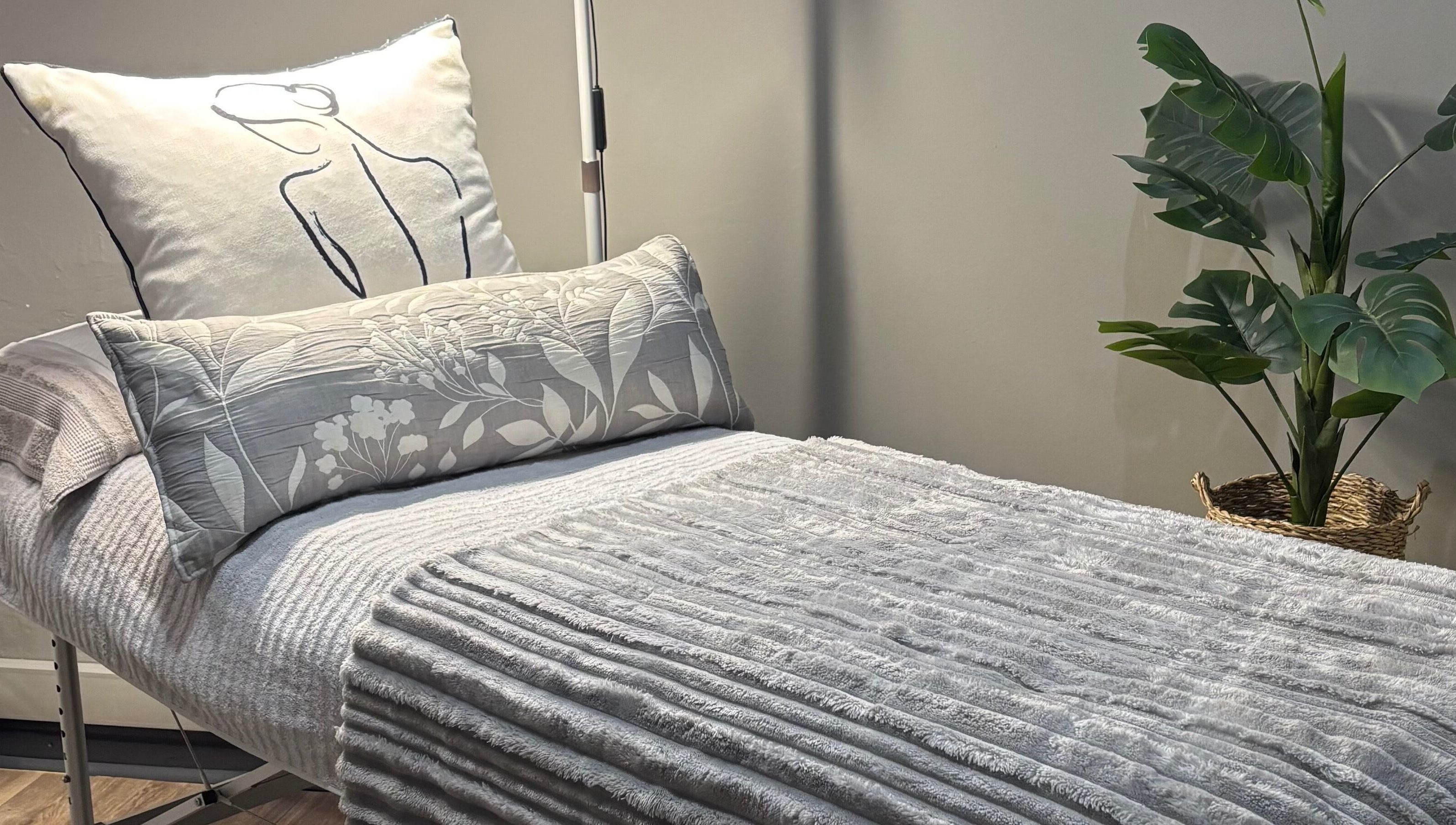 Relaxing bed setup at RosyTouch Aesthetics Ceres, Western Cape, ZA showcasing cozy pillows and calming decor.