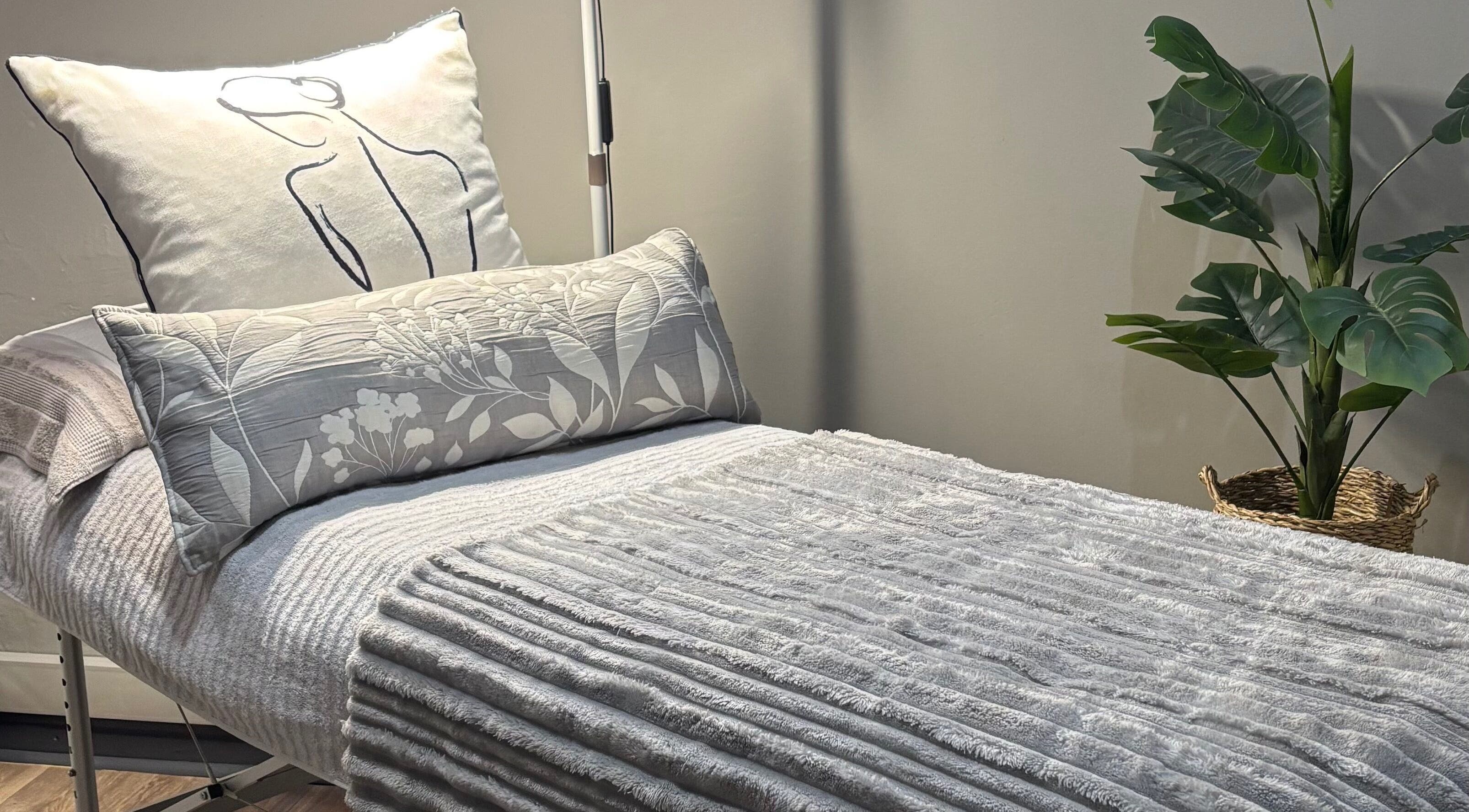 Relaxing bed setup at RosyTouch Aesthetics Ceres, Western Cape, ZA showcasing cozy pillows and calming decor.