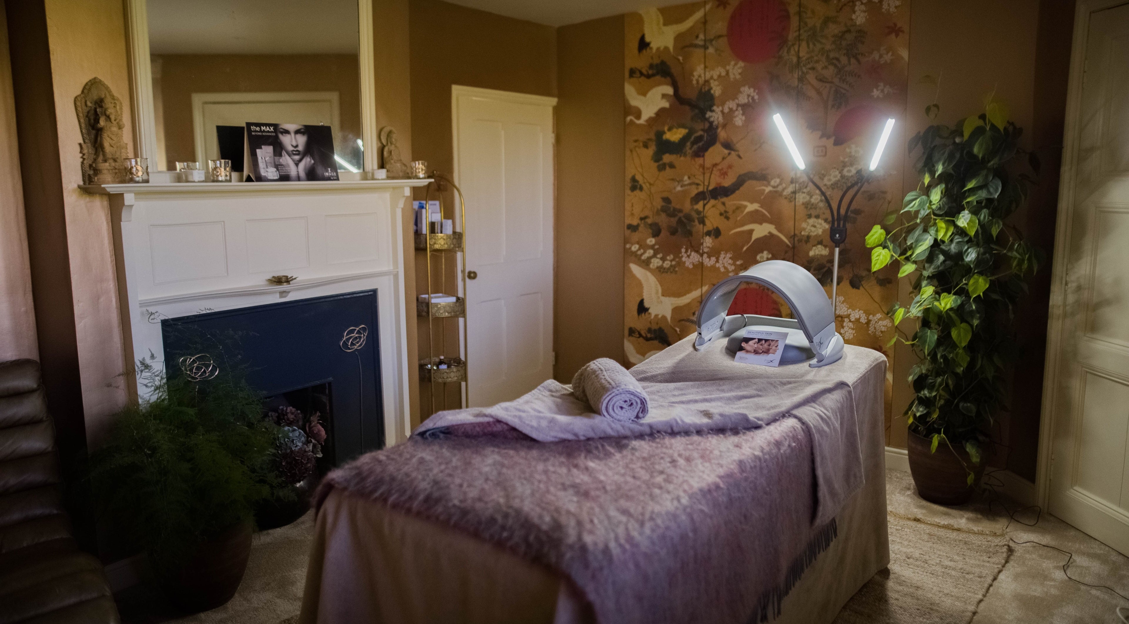 Cozy treatment room at Rejuvenate, Sibton, GB with massage table, soft lighting, and lush decor.