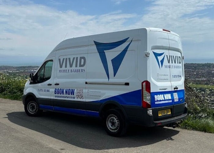 Vivid Mobile Barbers van parked with scenic Folkestone, England, GB view in backdrop.
