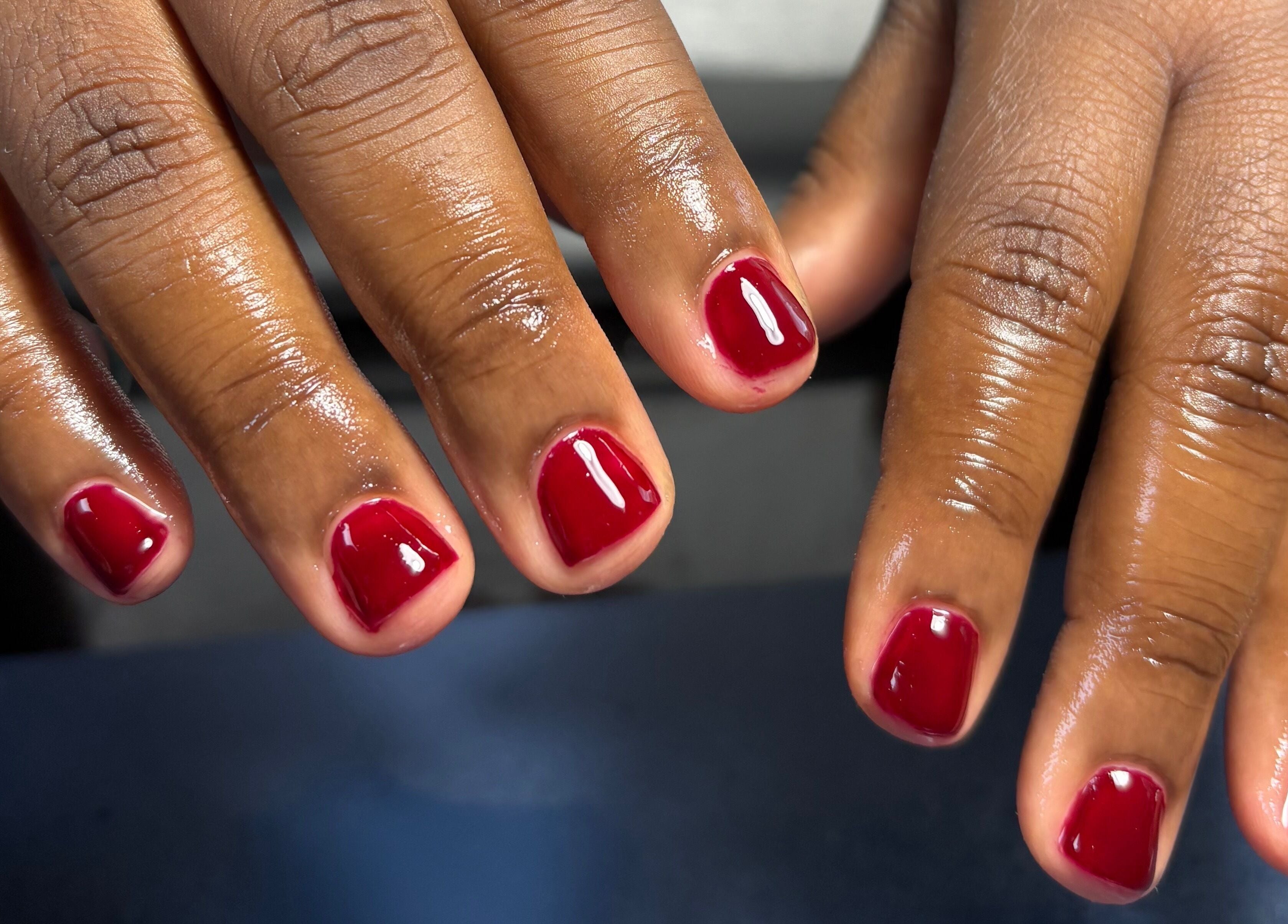 Red manicured nails at Tiffani Blu Studios, Atlanta, Georgia, US, showcasing expert nail care.